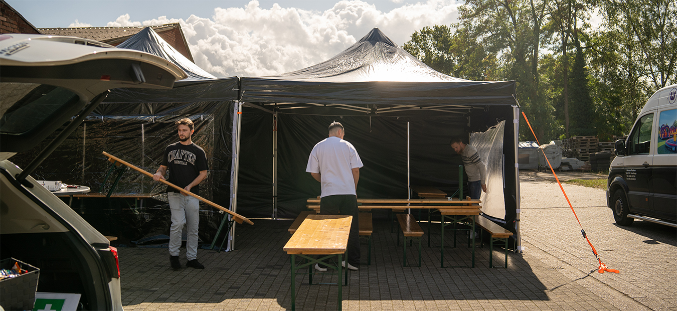 Team richtet Pavillons und Sitzbänke ein – letzte Handgriffe vor dem Start.